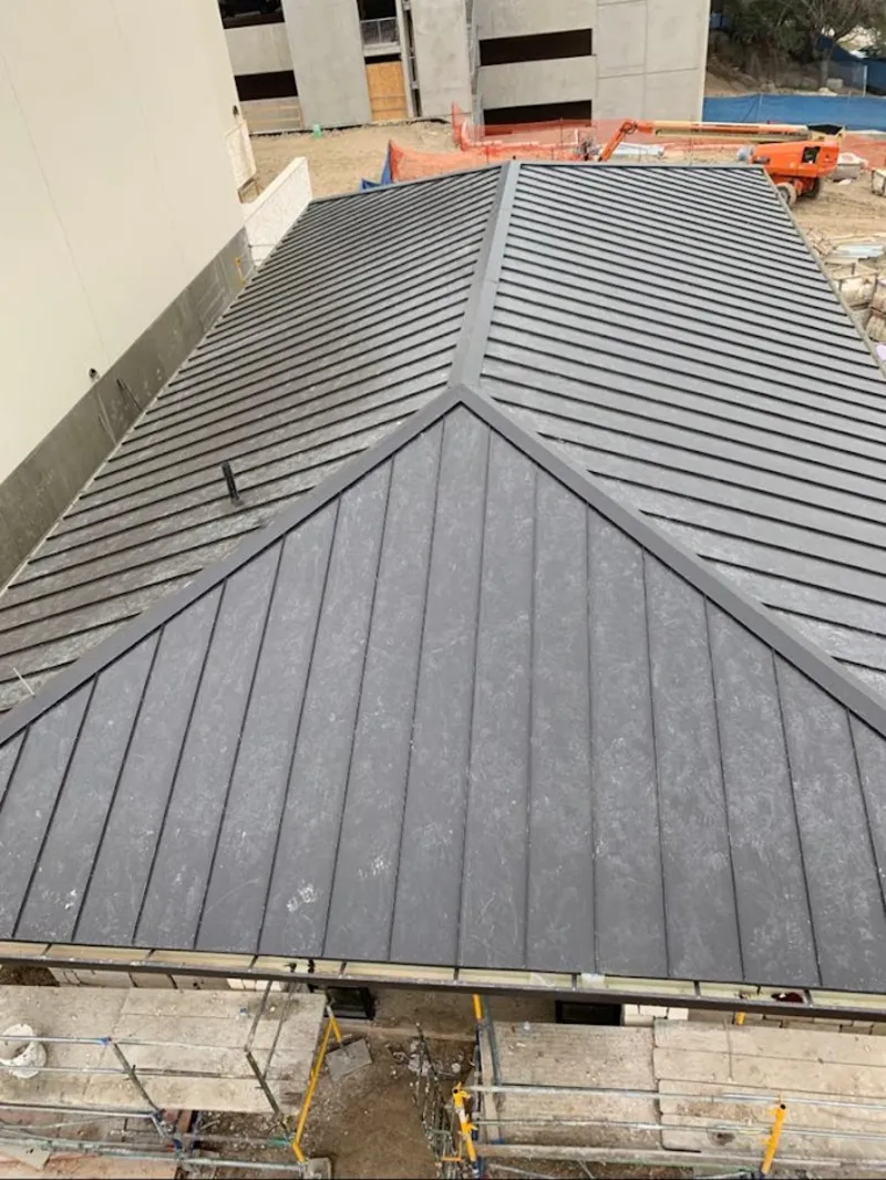Commercial metal roof construction with crane equipment in Spencer